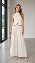 Front view of woman wearing beige sleeveless vest and wide-leg pants set