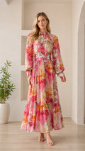 Front view of woman wearing pink floral long sleeve maxi dress