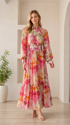 Front view of woman wearing pink floral long sleeve maxi dress