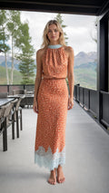 Front view of rust orange halter neck maxi dress with lace hem