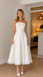 Front view of model wearing white strapless floral embroidered midi dress
