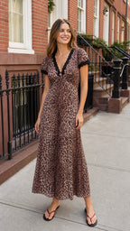 Front view of woman wearing brown leopard print maxi dress on city street