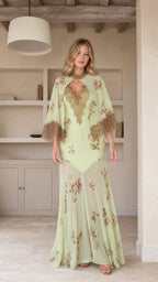 Model wearing mint green floral maxi dress with cape sleeves, front view