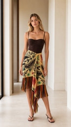 Model wearing yellow tropical print wrap skirt with fringe front view