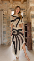Model wearing beige abstract knit two-piece crop top and maxi skirt set from front view