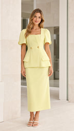 Front view of yellow square neck peplum top and midi skirt set