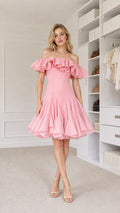 Front view of model wearing pink off-shoulder ruffle cocktail dress