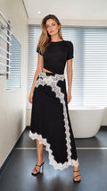 Model wearing black two-piece set with white lace trim, front view