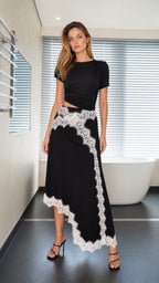 Model wearing black two-piece set with white lace trim, front view