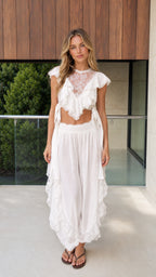 Front view of model wearing white boho lace ruffle crop top and harem pants set