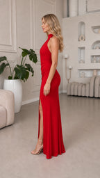 Side profile of model in red evening gown with leg slit