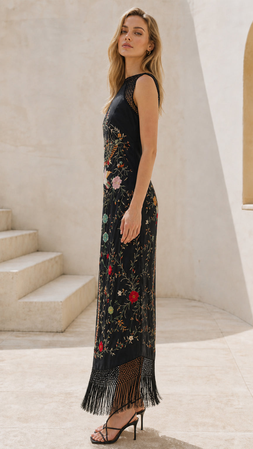 Side profile view of black embroidered fringe maxi dress