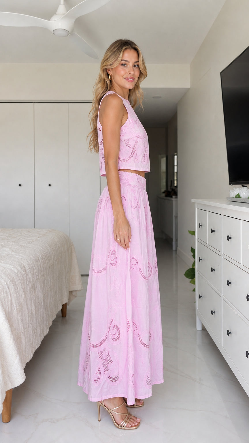 Side profile of model wearing pink two-piece set with side slit