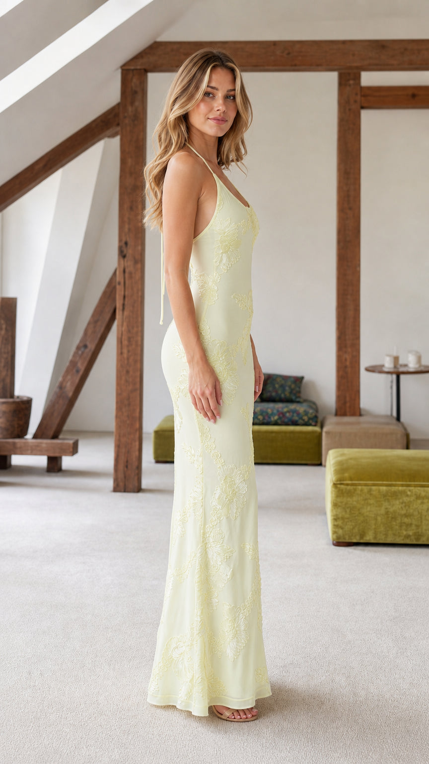 Side profile view of yellow halter maxi dress