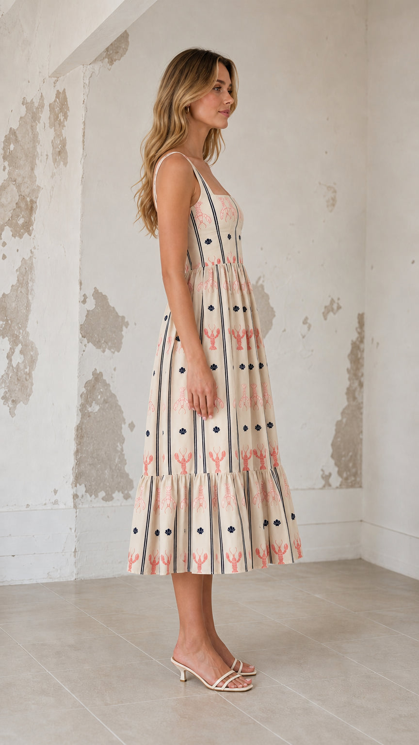 Side profile view of cream embroidered midi dress