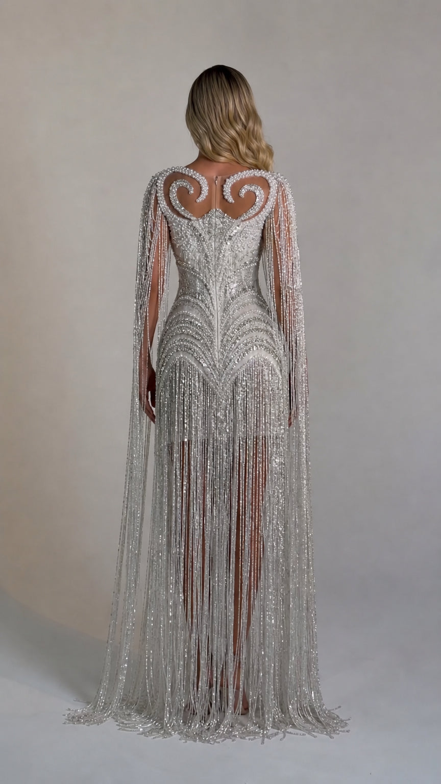 Back view showcasing the flowing cape sleeves and fringe