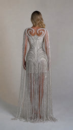 Back view showcasing the flowing cape sleeves and fringe