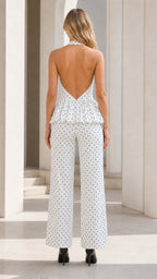 Back view showing open back and wide leg of white polka dot jumpsuit