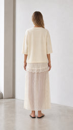 Back view of woman wearing cream tee and skirt set