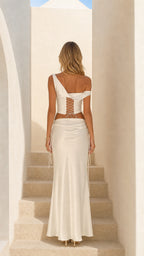 Back view of woman showing lace-up back detail on white satin top