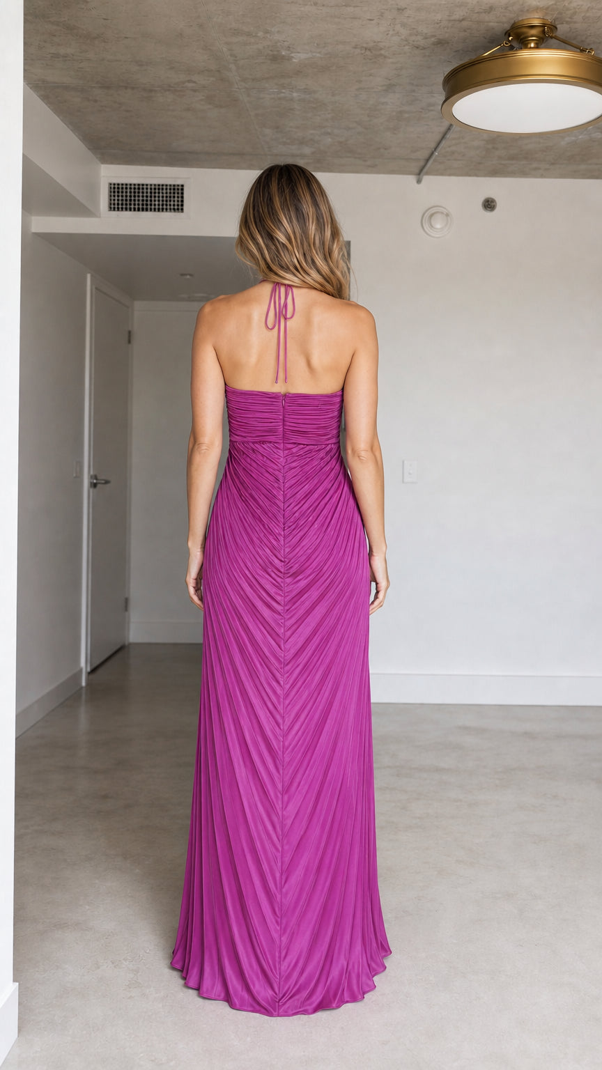 Back view of model showcasing open back and halter ties on Fuchsia dress