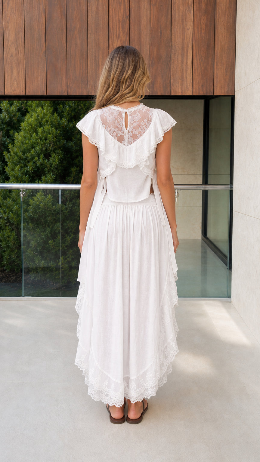 Back view of model showcasing lace back detail on white set