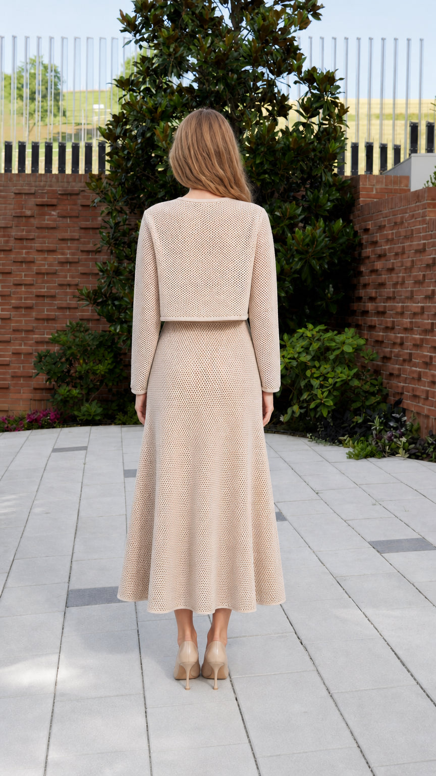 Back view of model wearing beige knit matching set