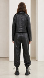 Model wearing black faux leather set showing back details