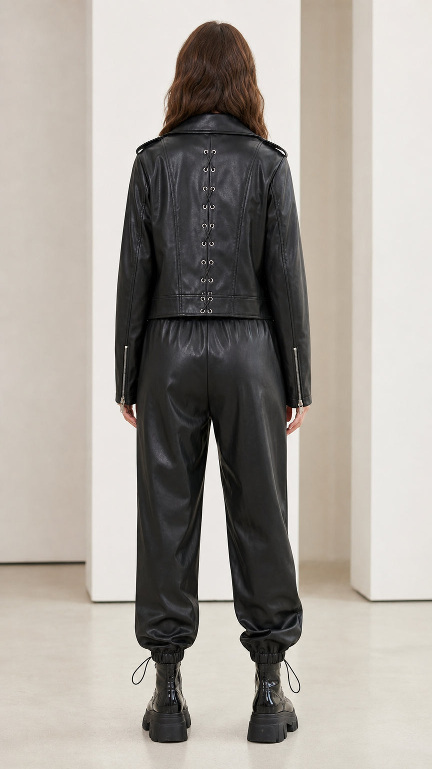 Model wearing black faux leather set showing back details