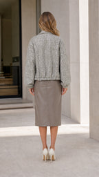 Back view of woman wearing grey tweed zip-up jacket