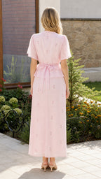 Back view showing tie-back detail on pink top and maxi skirt