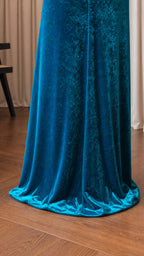 Close-up of floor-length hem on teal velvet dress