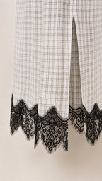 Close-up of lower hem detail showing side slit and scalloped black lace