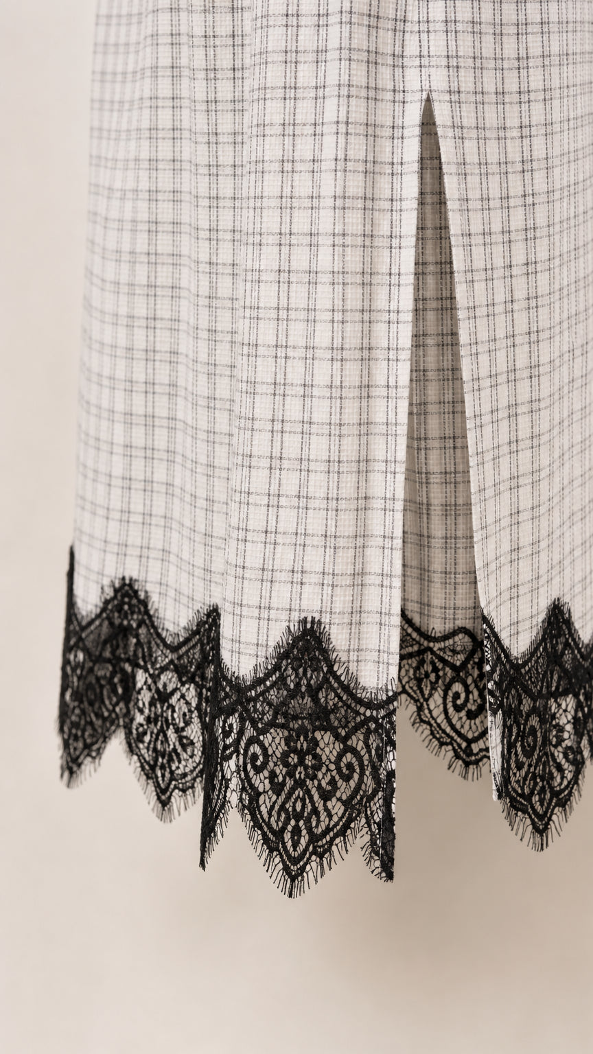 Close-up of lower hem detail showing side slit and scalloped black lace