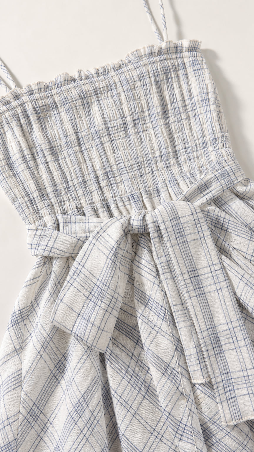 Close-up of smocked bodice and tie detail on plaid dress