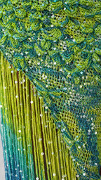 Close-up detail of green blue sequin texture and ombre fringe hem