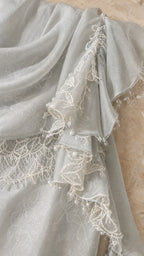Close-up detail of lace trim, ruffles, and bead embellishments