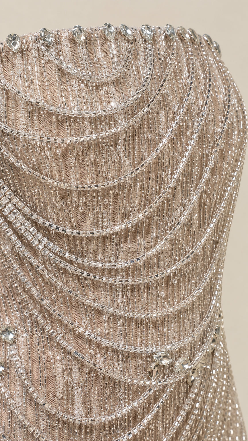 Close-up detail of shimmering beadwork and draped chains on dress bodice