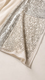 Close-up detail of sequin and metallic ring embellishments on fabric