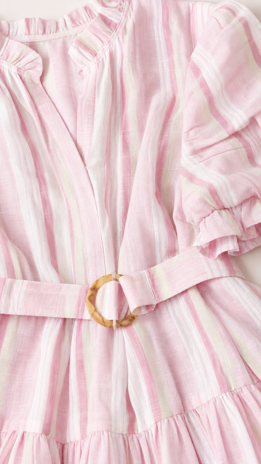Close-up detail of fabric, V-neck, and belt on pink striped dress