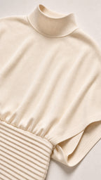 Close up of mock neck and ribbed waistband detail on cream dress