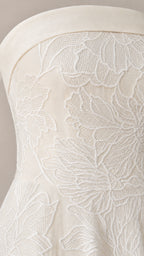 Close-up detail of white floral embroidery on strapless dress bodice