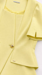 Close-up detail of yellow jacket neckline and gold buttons