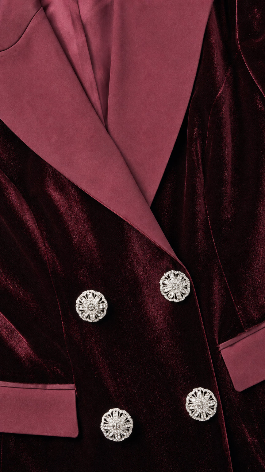 Close-up of contrast lapels and jeweled buttons on burgundy blazer dress