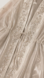 Close-up detail of front tie closure and intricate silver embroidery