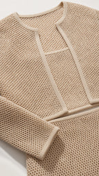 Close-up detail of beige textured knit fabric and jacket trim