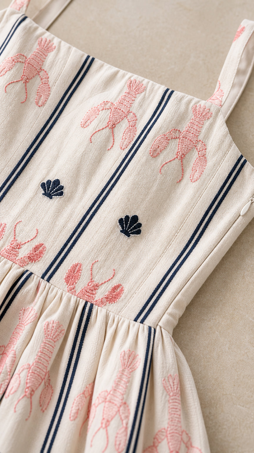 Close-up detail of lobster and seashell embroidery on fabric