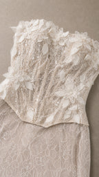 Close-up detail of 3D floral appliques and textured lace on bodice